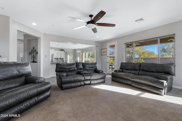 living room with carpet flooring and ceiling fan with notable chandelier