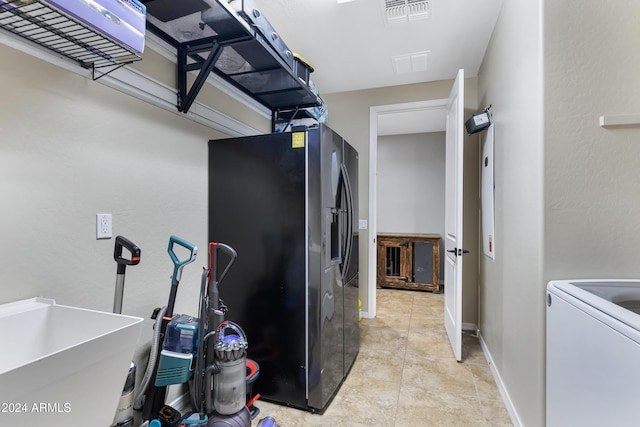 washroom with washer / dryer, light tile patterned floors, and sink