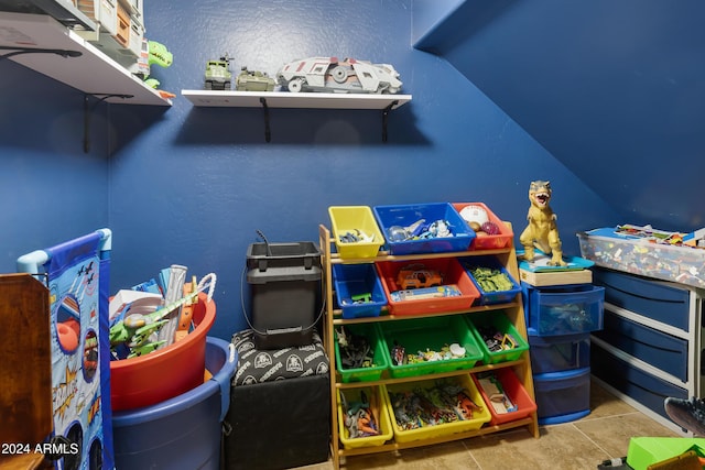 game room featuring light tile patterned floors and vaulted ceiling