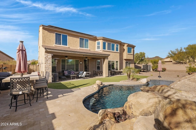 back of house featuring ceiling fan, a patio area, and a fenced in pool