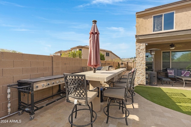 view of patio / terrace featuring ceiling fan and a bar