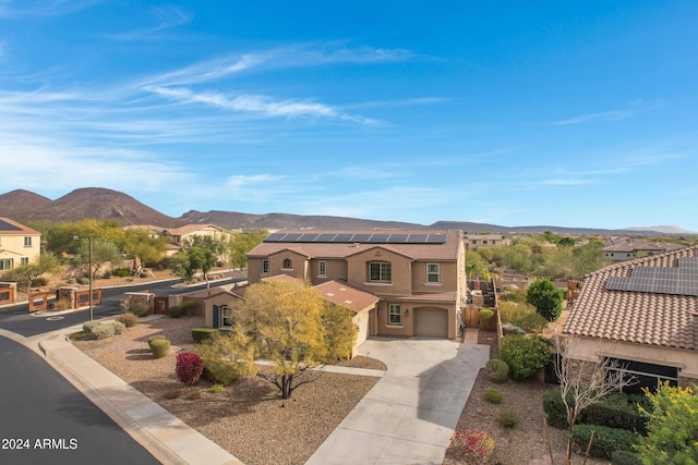 view of front of house featuring a mountain view, solar panels, and a garage