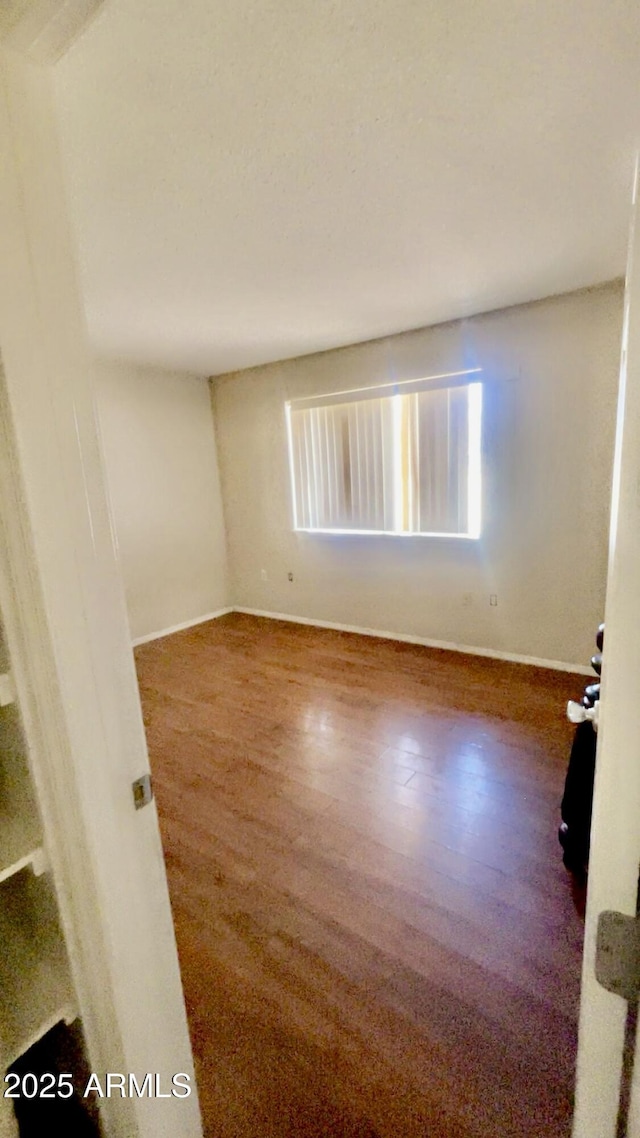 3404 W Tangerine Ln, Phoenix, AZ 85051 - empty room with baseboards and wood finished floors