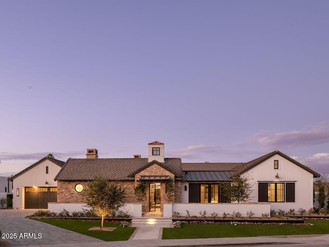 view of front of home featuring a standing seam roof, metal roof, and decorative driveway