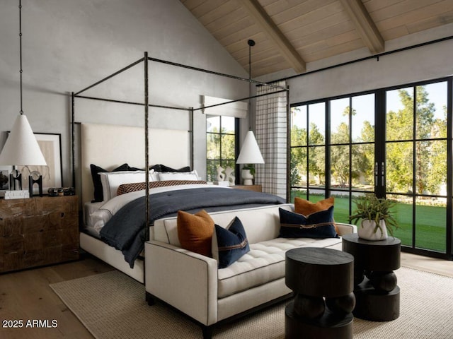 bedroom with multiple windows, high vaulted ceiling, wood finished floors, and beamed ceiling