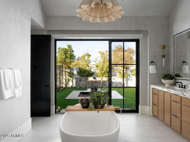 doorway with a chandelier, plenty of natural light, a sink, and light tile patterned flooring