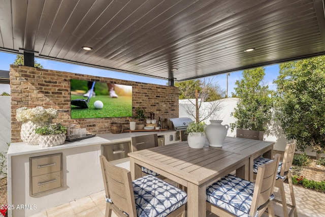 view of patio with a grill, fence, area for grilling, and outdoor dining space