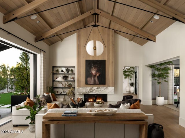 living area with wooden ceiling, a fireplace, high vaulted ceiling, and beamed ceiling