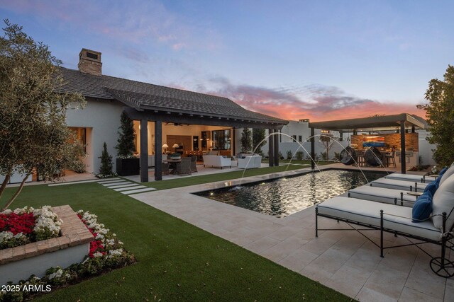 pool at dusk with a lawn, a fenced in pool, fence, a patio area, and outdoor lounge area