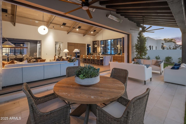 dining area with light tile patterned floors, high vaulted ceiling, beamed ceiling, and a ceiling fan