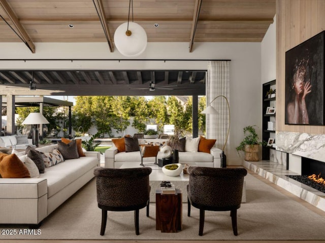 living area with wooden ceiling, a fireplace, and beamed ceiling