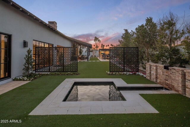 yard at dusk featuring a patio and fence