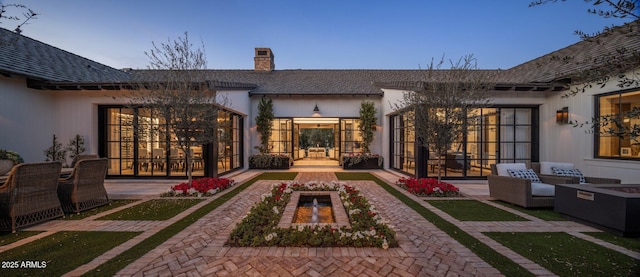 rear view of property with a patio area and a chimney