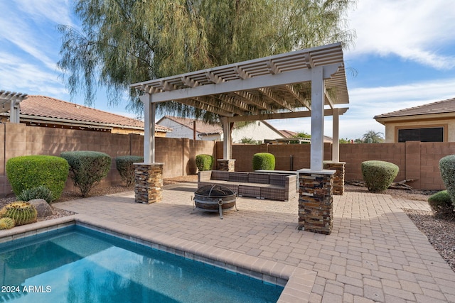 view of swimming pool with a pergola, a patio, and an outdoor living space with a fire pit