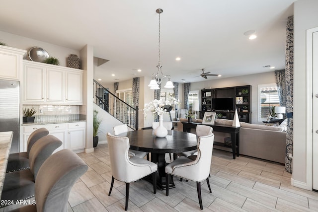 dining area with ceiling fan with notable chandelier