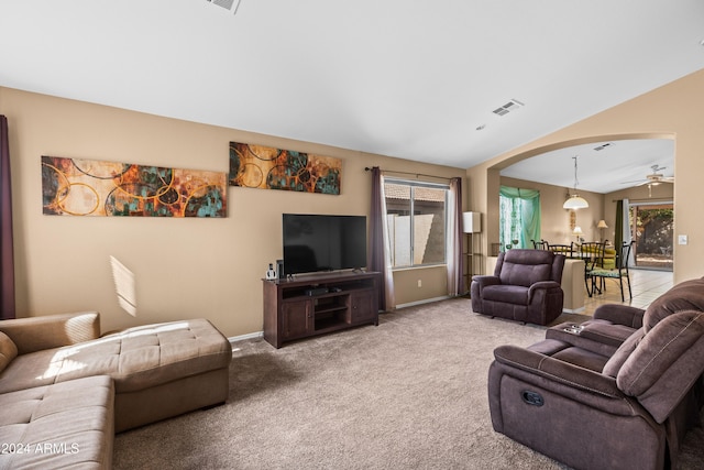 living room featuring carpet flooring, ceiling fan, and vaulted ceiling