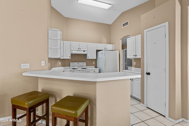 kitchen with kitchen peninsula, a breakfast bar, white appliances, white cabinets, and lofted ceiling