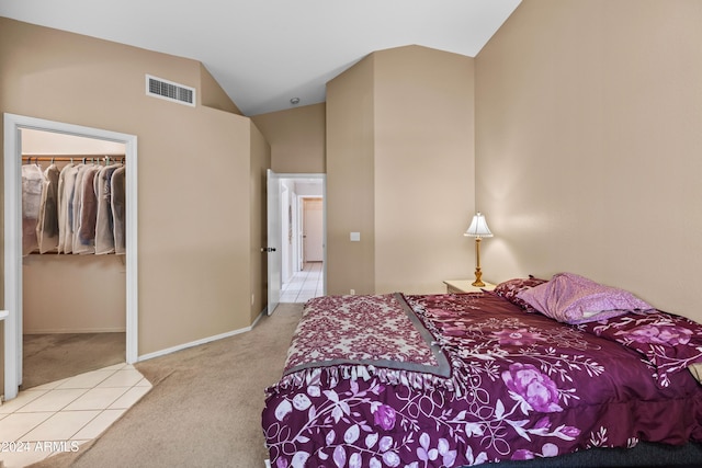 bedroom with a spacious closet, a closet, high vaulted ceiling, and light carpet