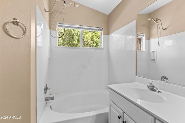 bathroom featuring bathing tub / shower combination, vanity, and vaulted ceiling