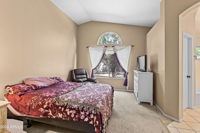 bedroom featuring light colored carpet and vaulted ceiling