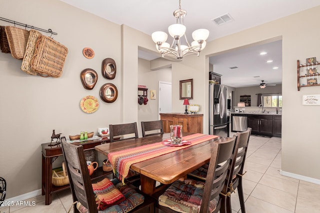 tiled dining space with sink and ceiling fan with notable chandelier