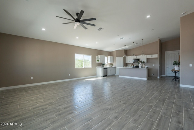 unfurnished living room featuring ceiling fan and lofted ceiling