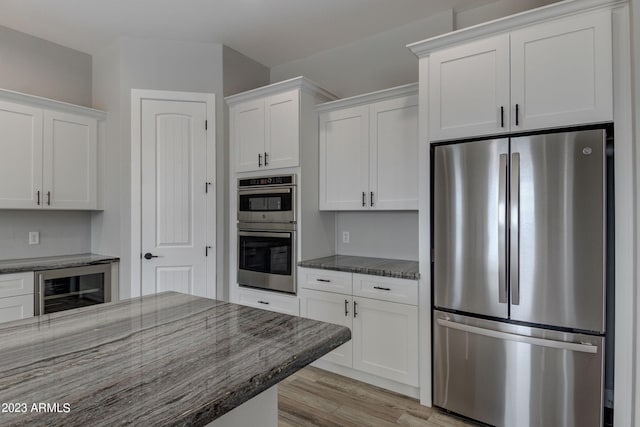 3785 W Silverdale Rd, Queen Creek, AZ 85144 - kitchen with appliances with stainless steel finishes, white cabinetry, and dark stone countertops