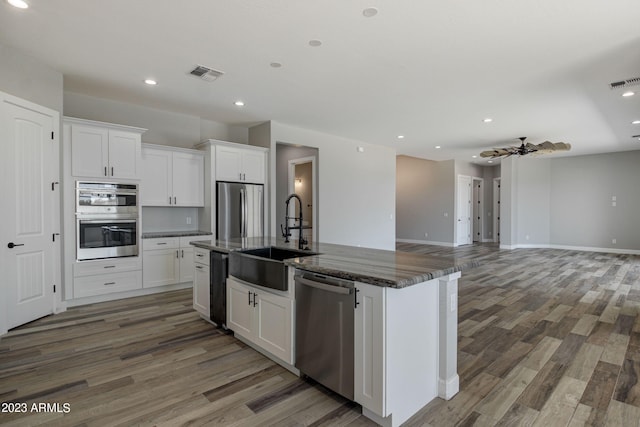 3785 W Silverdale Rd, Queen Creek, AZ 85144 - kitchen with appliances with stainless steel finishes, sink, hardwood / wood-style floors, and an island with sink