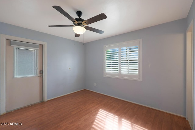 empty room featuring baseboards, a ceiling fan, and wood finished floors