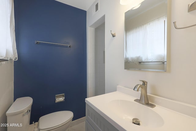 bathroom with visible vents, vanity, and toilet