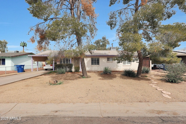 single story home with driveway, a chimney, and an attached carport