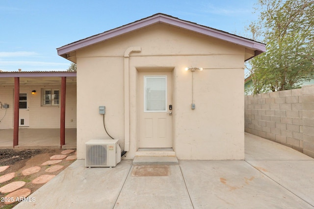 view of outdoor structure with ac unit and fence