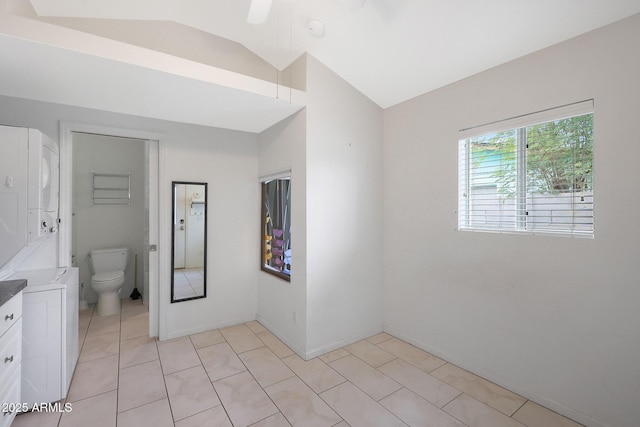 bathroom with vaulted ceiling, vanity, toilet, and tile patterned floors