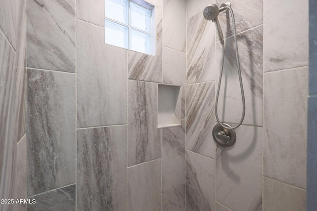 interior details featuring a tile shower