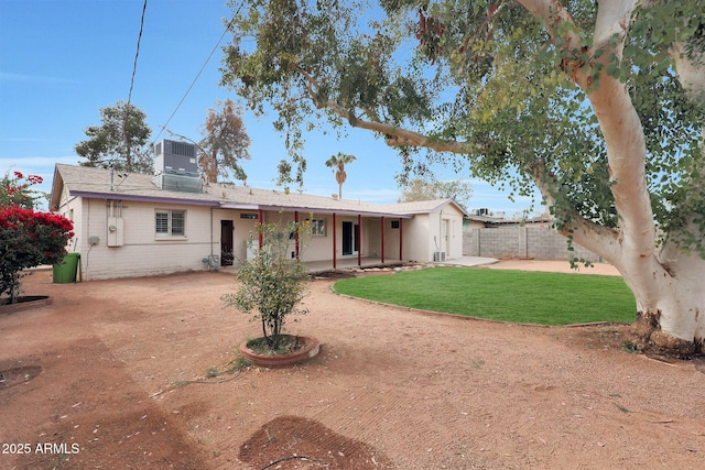 rear view of house with driveway, fence, cooling unit, a yard, and a patio area