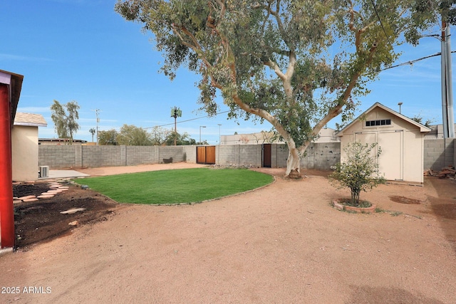 view of yard with a shed, an outdoor structure, and a fenced backyard