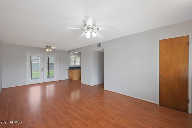 unfurnished living room with ceiling fan, french doors, wood finished floors, and visible vents