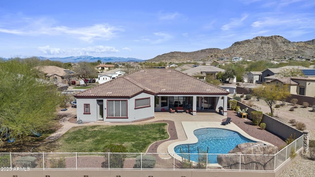 back of property featuring a fenced backyard, a tile roof, a mountain view, and a patio