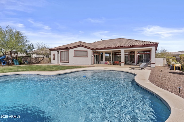 view of swimming pool featuring a fenced in pool, a playground, a lawn, a patio area, and a fenced backyard