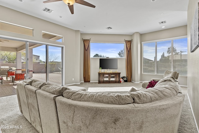 carpeted living room featuring plenty of natural light, visible vents, and baseboards