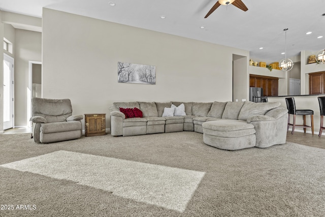 carpeted living area with recessed lighting, ceiling fan, and a high ceiling