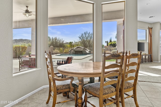 dining space with baseboards, a textured wall, and a healthy amount of sunlight