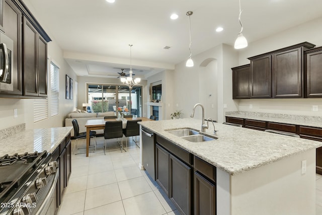 kitchen with appliances with stainless steel finishes, ceiling fan, a kitchen island with sink, sink, and decorative light fixtures