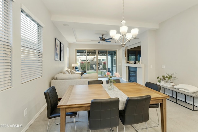 tiled dining room with ceiling fan with notable chandelier, beverage cooler, and a tray ceiling