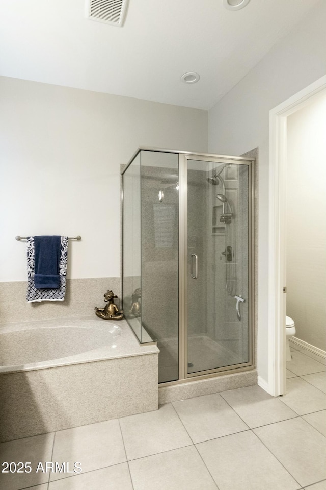 bathroom featuring tile patterned floors, shower with separate bathtub, and toilet