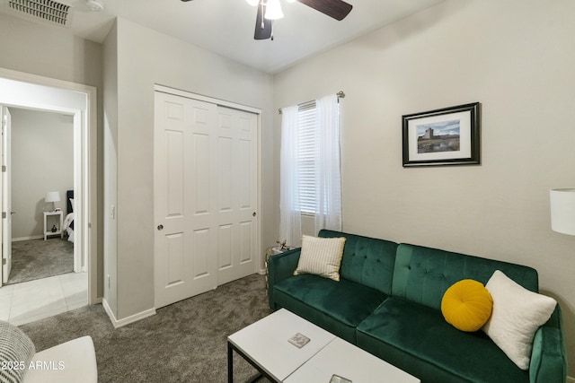 living room with ceiling fan and dark colored carpet