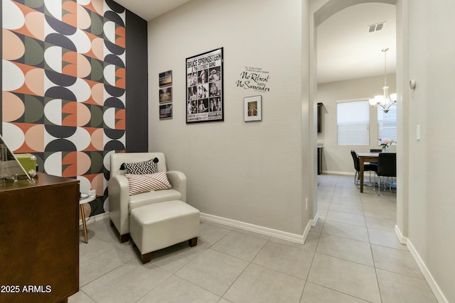 sitting room with light tile patterned flooring and a chandelier