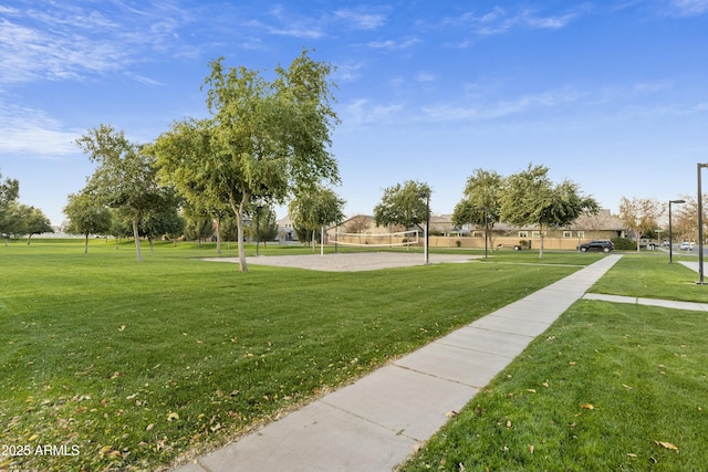 surrounding community with volleyball court and a lawn