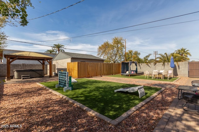 view of yard featuring a gazebo, a trampoline, a hot tub, and a patio area