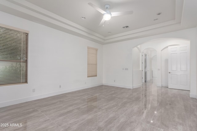 4711 E Buckboard Ct, Gilbert, AZ 85297 - spare room with a tray ceiling, ceiling fan, arched walkways, and baseboards